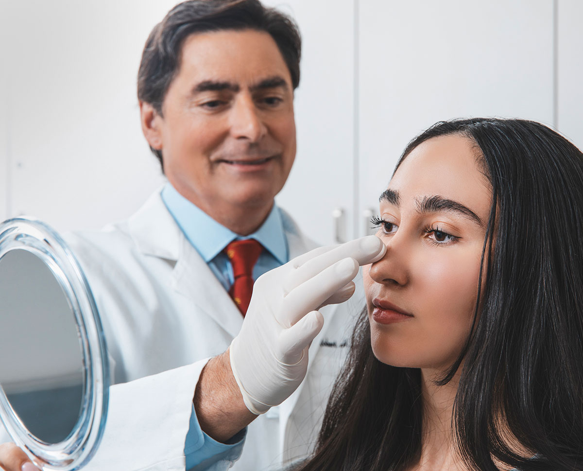 Dr. Guida, a facial plastic surgeon in NYC, examines a patients nose