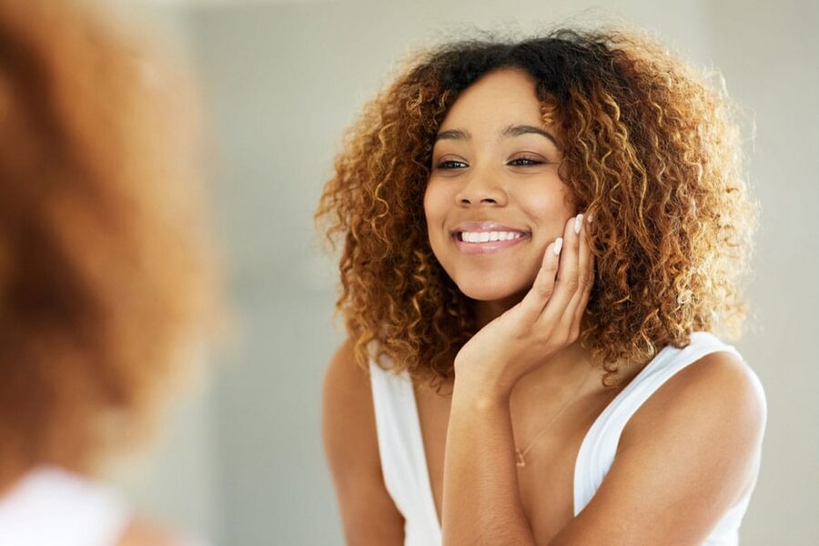 woman looking in the mirror after her facelift in NYC